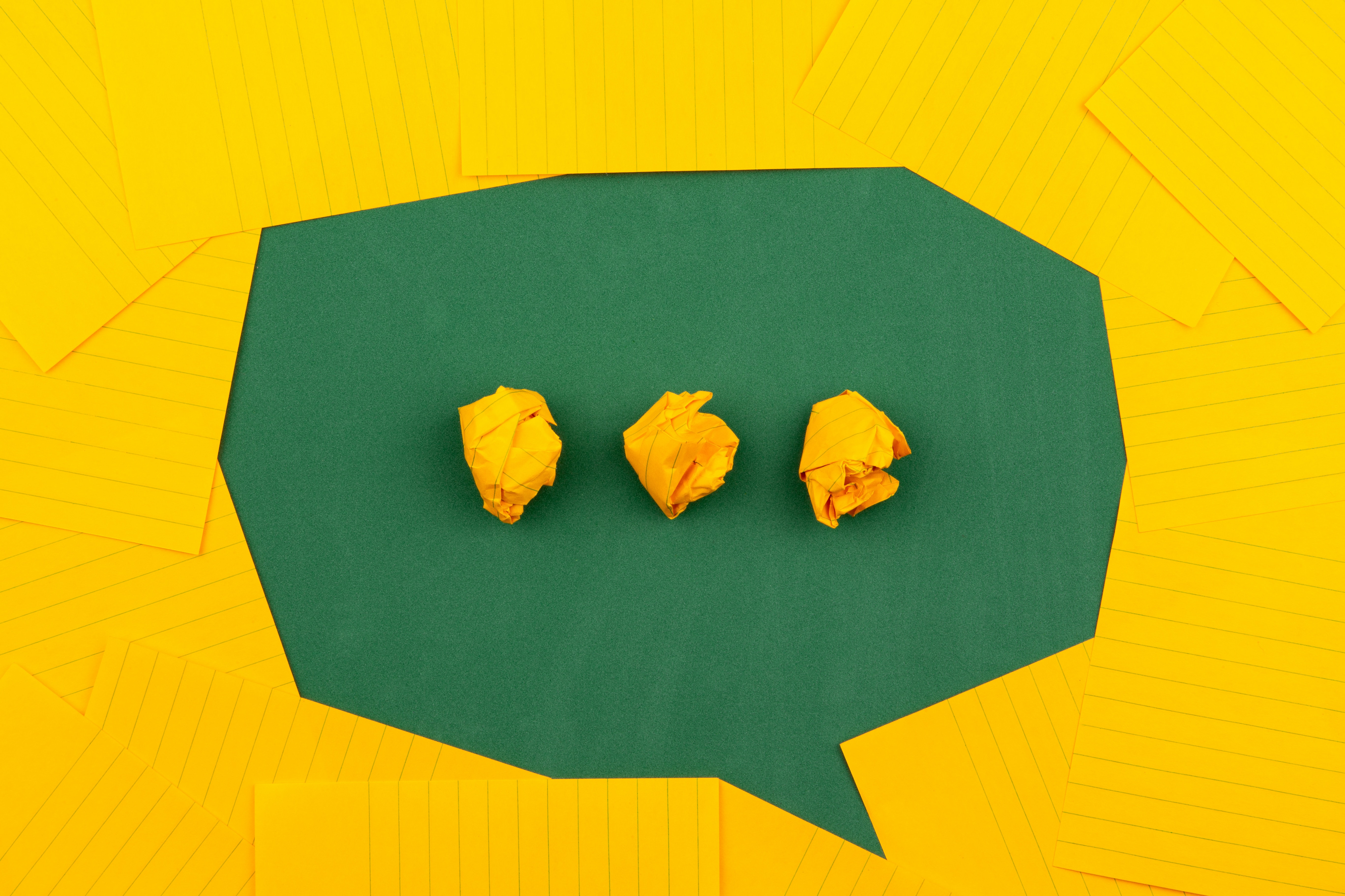 Stock image of a green text bubble on a yellow background
